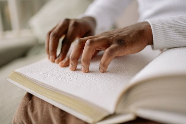 blind person's rights in Israel - person reading book in braille